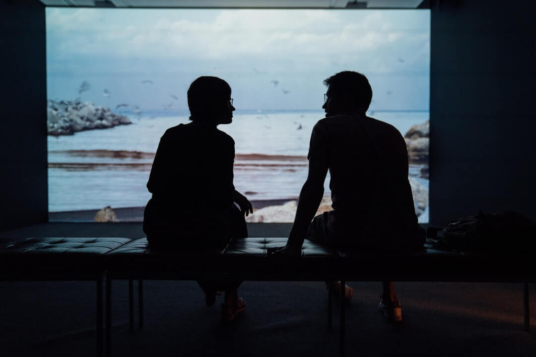 A person sitting across a small table from a partner during a calm, honest breakup conversation